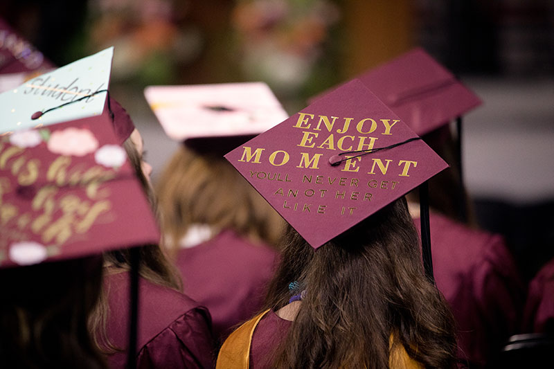 大学学位帽上写着“享受每一刻”