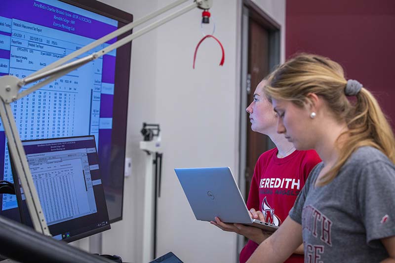 运动和体育科学专业的学生在大屏幕上查看数据