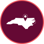 maroon icon with an outline of north carolina and a mark where Raleigh is located