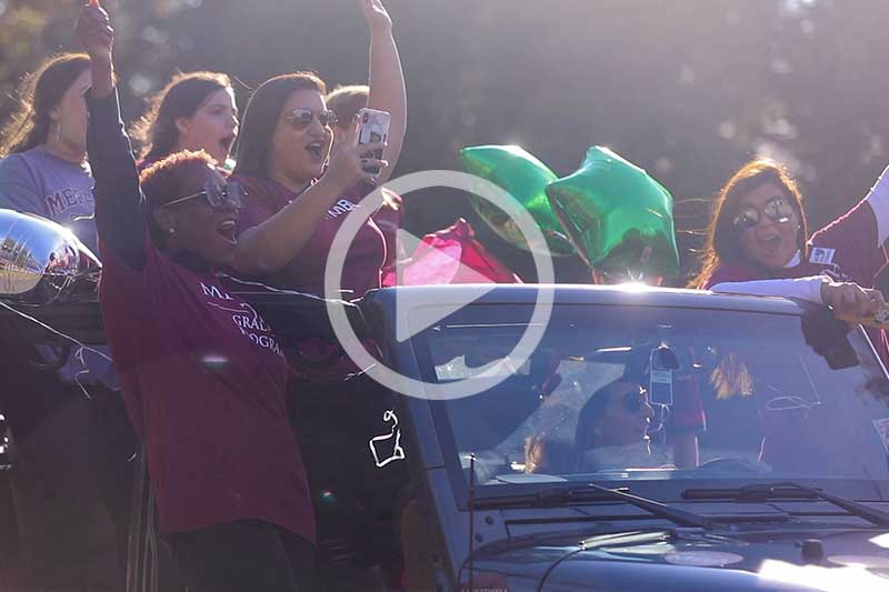 MBA students riding car in Raleigh Christmas Parade