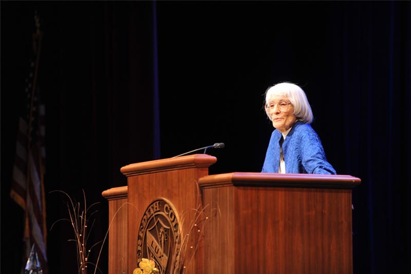 Bernice Sandler speaks at Meredith College behind a lectern with the College seal on it