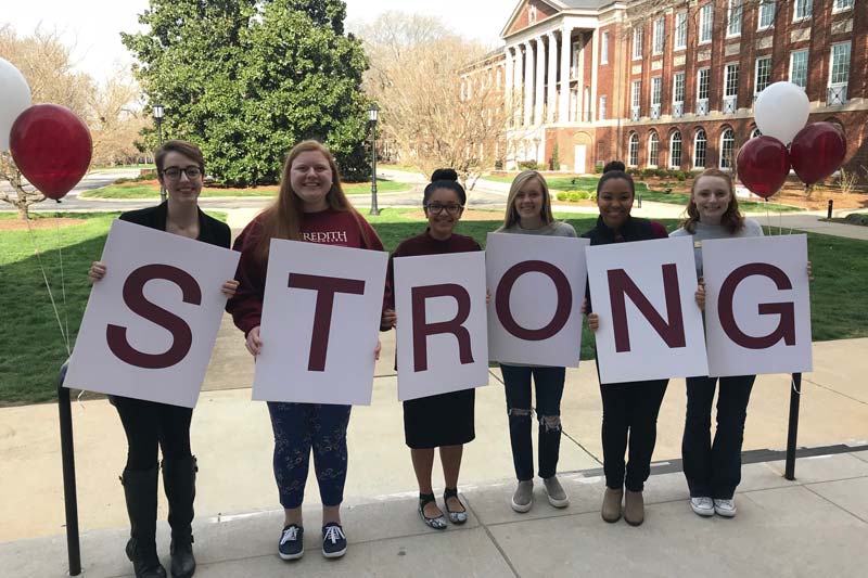 Six students holding letters that spell out STRONG