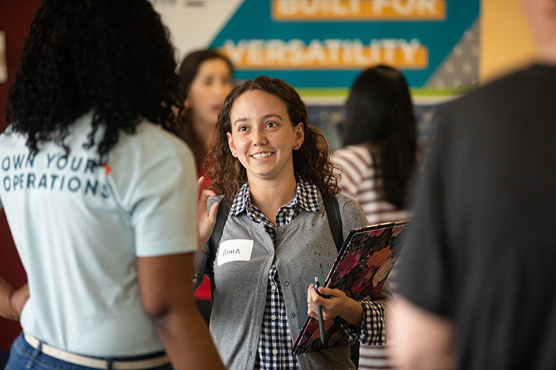 a student smiling while talking to recruiters