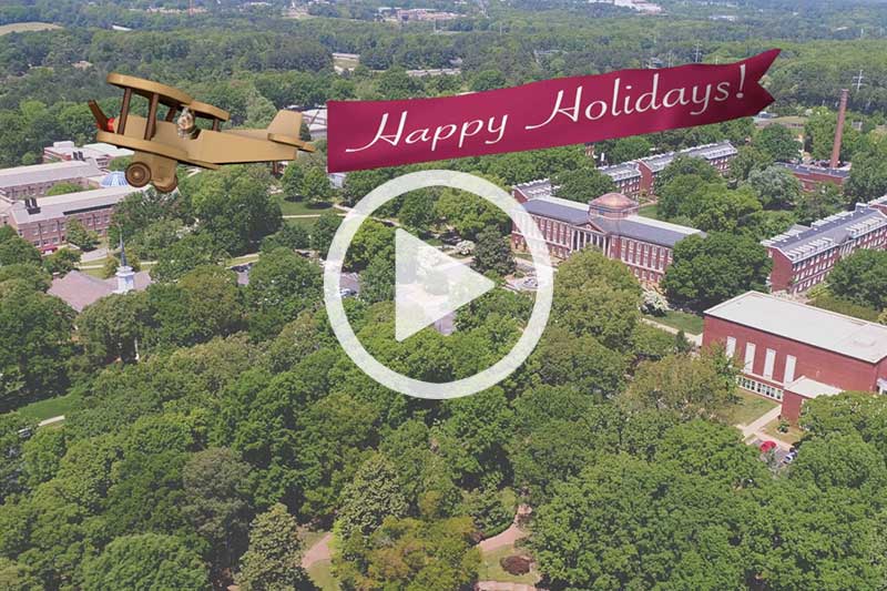 Click image of plane flying over campus to watch Bachelor's Holiday Flight video in modal