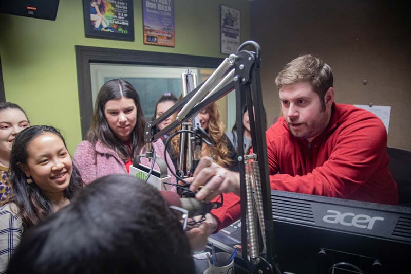 radio host showing students behind the scenes at rec