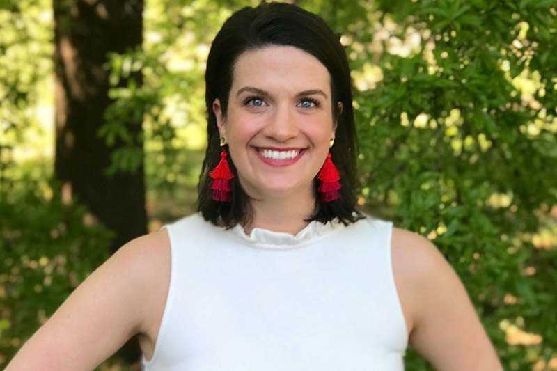 Image of Ellison White wearing white top and red earrings