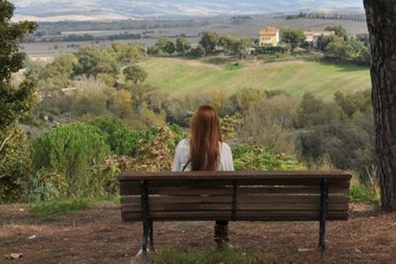 Student Seated on Bench overlooking Italian Countryside.
