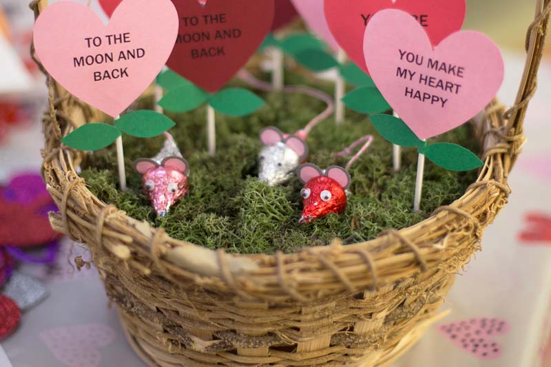 Basket with construction paper hearts with Valentines messages written on them