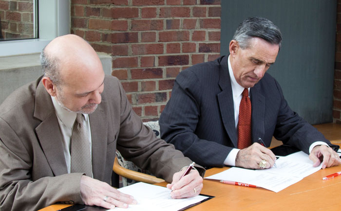 Matthew Poslusny and John Rocovich, Jr. from VCOM pictured together signing the new articulation agreement.
