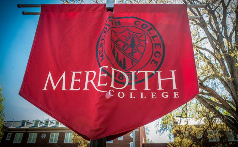 Maroon banner with the words Meredith College in white. The college's seal is in the background in black