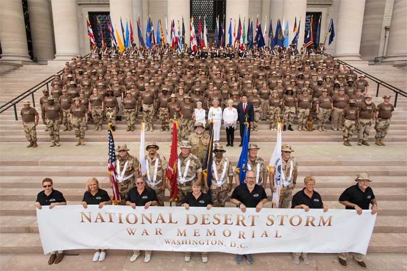 Troops posing in front of sign that reads Desert Storm