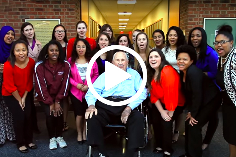 Click on image of Portor Byrum seated in chair with students to watch his donor video in modal