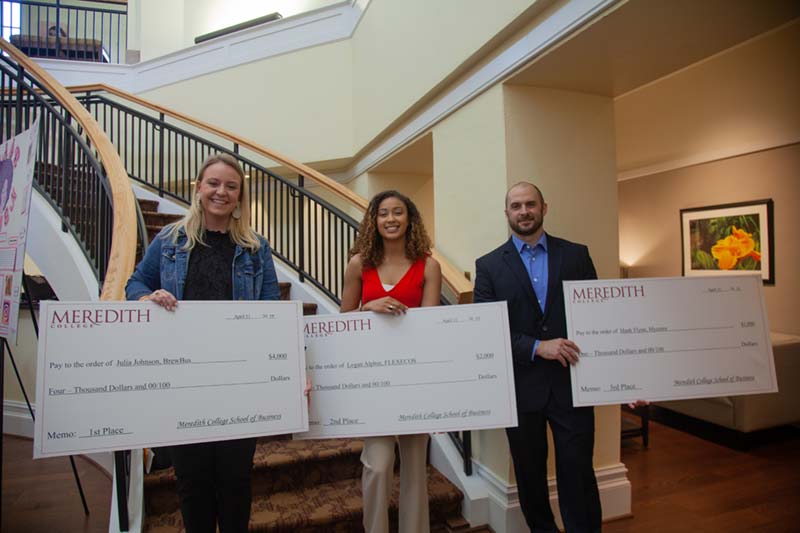 Three Entrepreneurship Challenge Winners holding their payment check