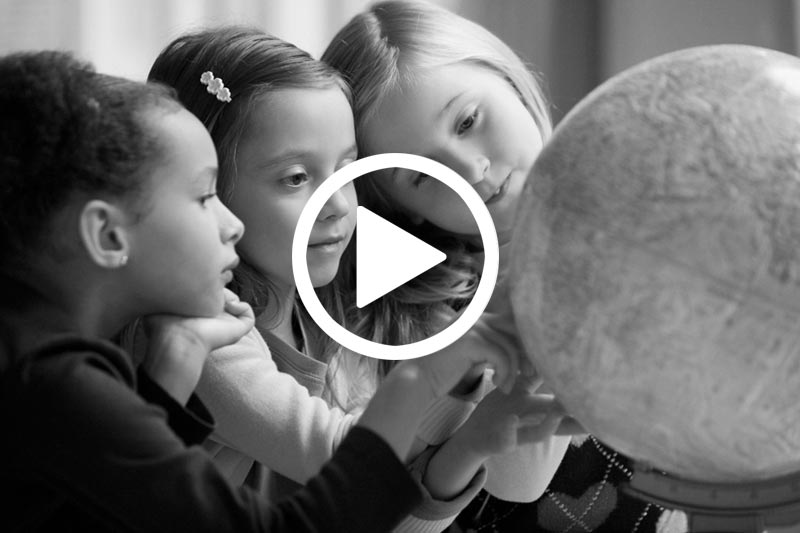 click on image of girls looking at Globe to watch a video about the Status of Girls