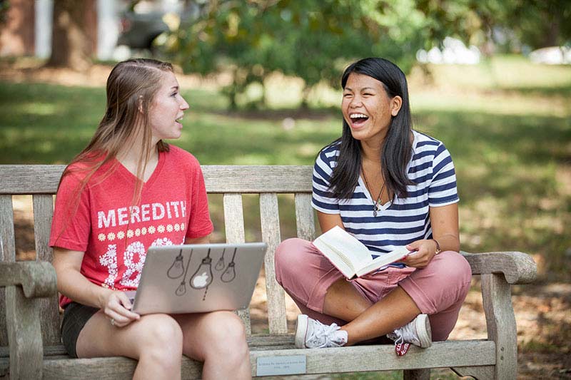 Two Meredith College students talking outside a residence hall