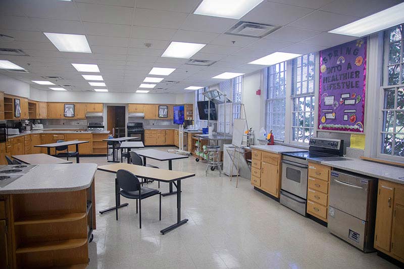Image showing a classroom with tables for students, ovens, drawers, and stovetops.