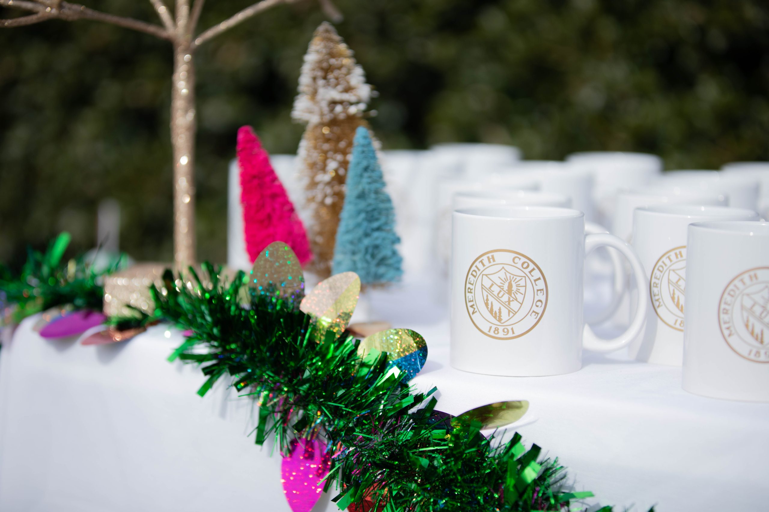 Table with holiday decorations and Meredith mugs