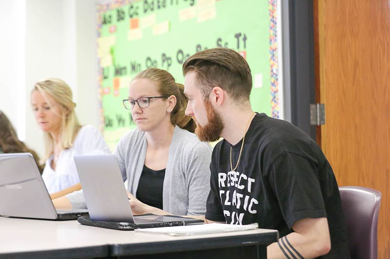 Students work on laptops in the classroom.