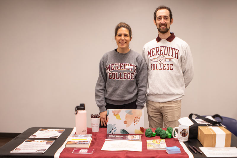 M.S. in Nutrition students Laura Sans and Kevin Manbeck staffing information table at Meredith College Basic Needs Fair.