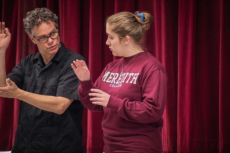 A student works with a professor on conducting.