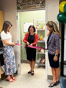 Faculty and Staff cutting the ribbon for the new Martin Market as part of the Daisy Trade.