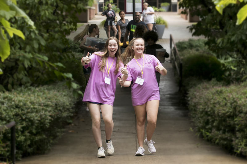 Two students smiling while walking through Meredith courtyard