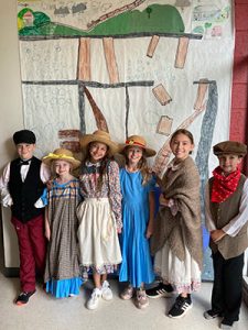 Six kids in costumes from the 2023 Performing Arts Camp smiling.