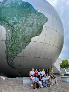 International Students at Museum posing in front of large globe.