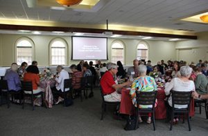 Retired faculty and staff eat at round tables together during the retire faculty and staff luncheon on campus in October 2023.