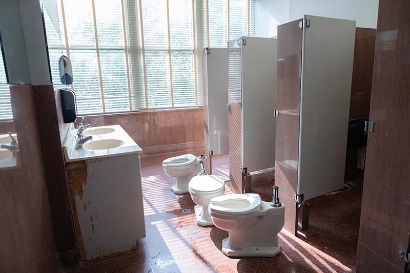 The bathroom with large windows and all of the toilets removed for renovation.