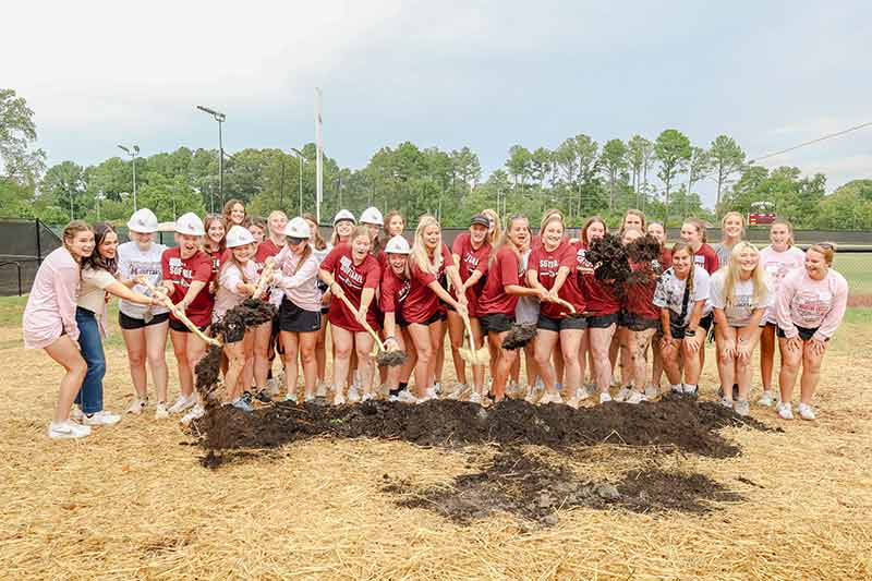 Meredith athletes hold a shovel for the ground breaking of the new athletic complex.