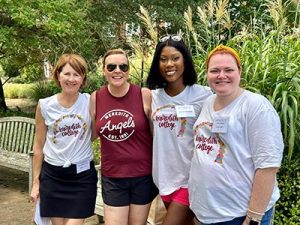 Four Meredith Alums posting together in 91Ƶ T-shirts.