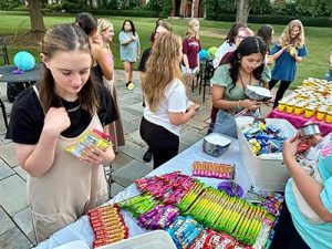 Meredith Students selecting candy goodies at Alumnae table.