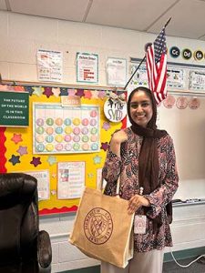 New 3rd Grade Teacher Zaineb Syded holding Meredith bag with school supplies.