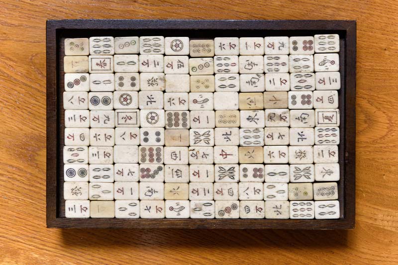 Mahjong Game Board and pieces on a wooden table.